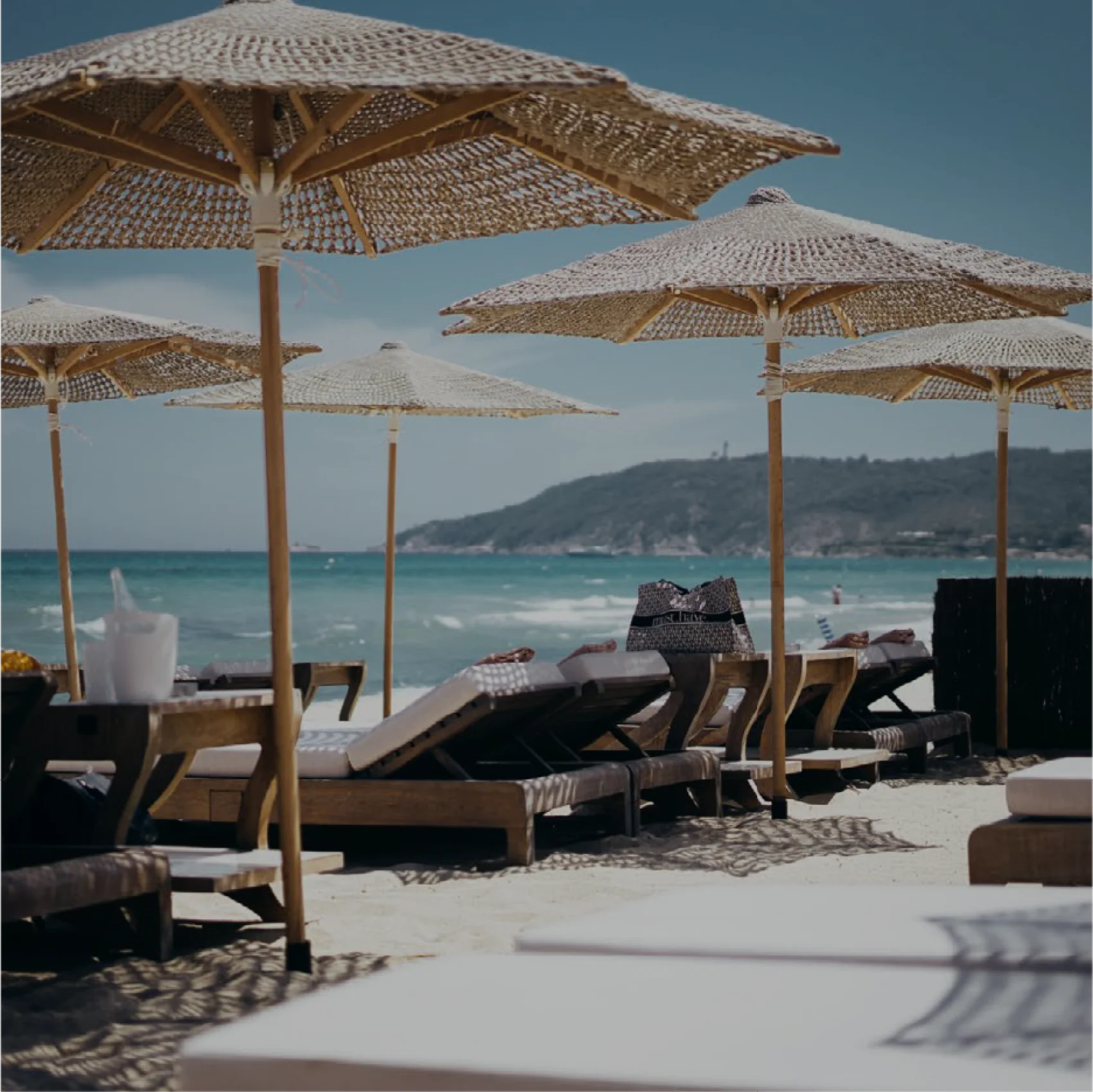 Hasır şemsiyeli, deniz kenarında beach club